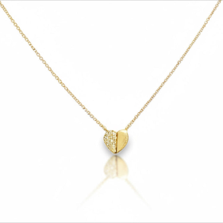 Gold heart-shaped necklace on a white background