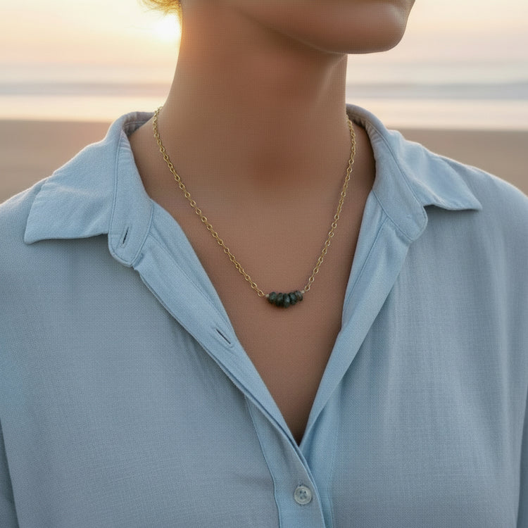 Gold necklace with gray green Labradorite beads on a white background