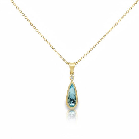 Elongated teardrop aquamarine pendant set in 14K yellow gold bezel setting with satin finish