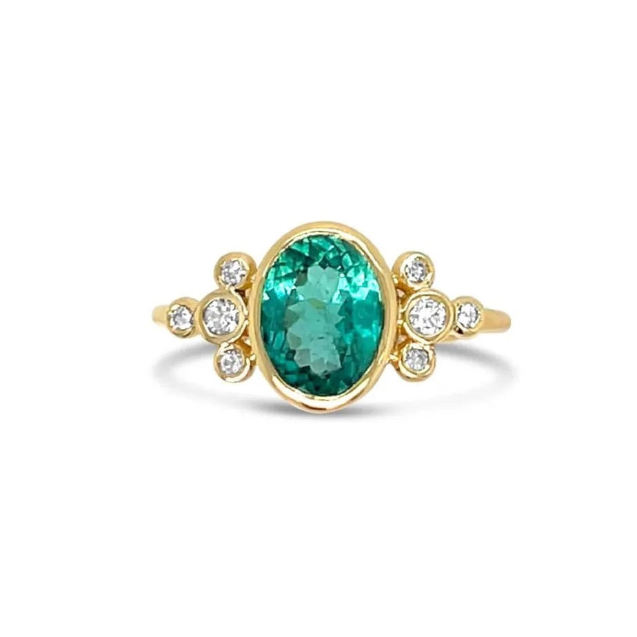 Gold ring with a green tourmaline gemstone and small diamonds on a white background