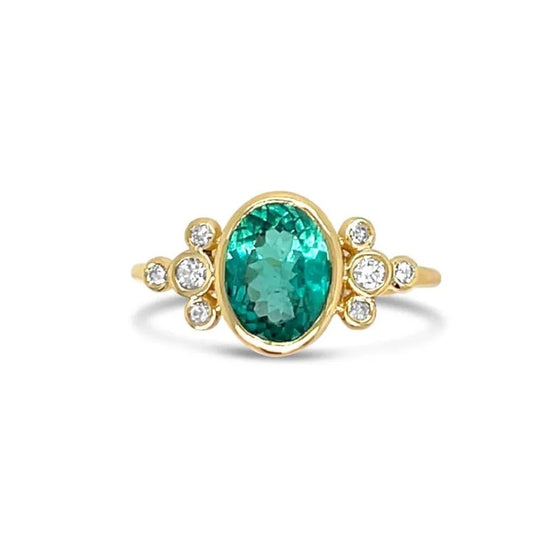 Gold ring with a green tourmaline gemstone and small diamonds on a white background