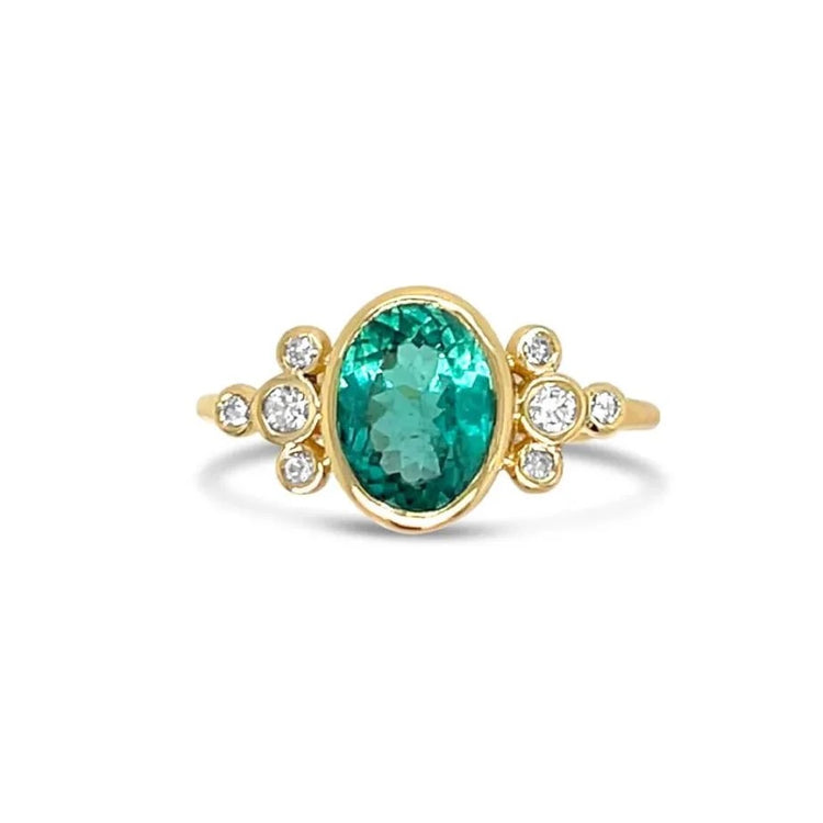 Gold ring with a green tourmaline gemstone and small diamonds on a white background