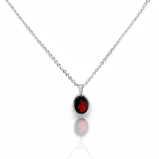 Silver necklace with a red garnet gemstone pendant on a white background