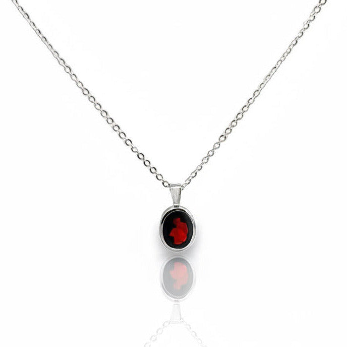 Silver necklace with a red garnet gemstone pendant on a white background