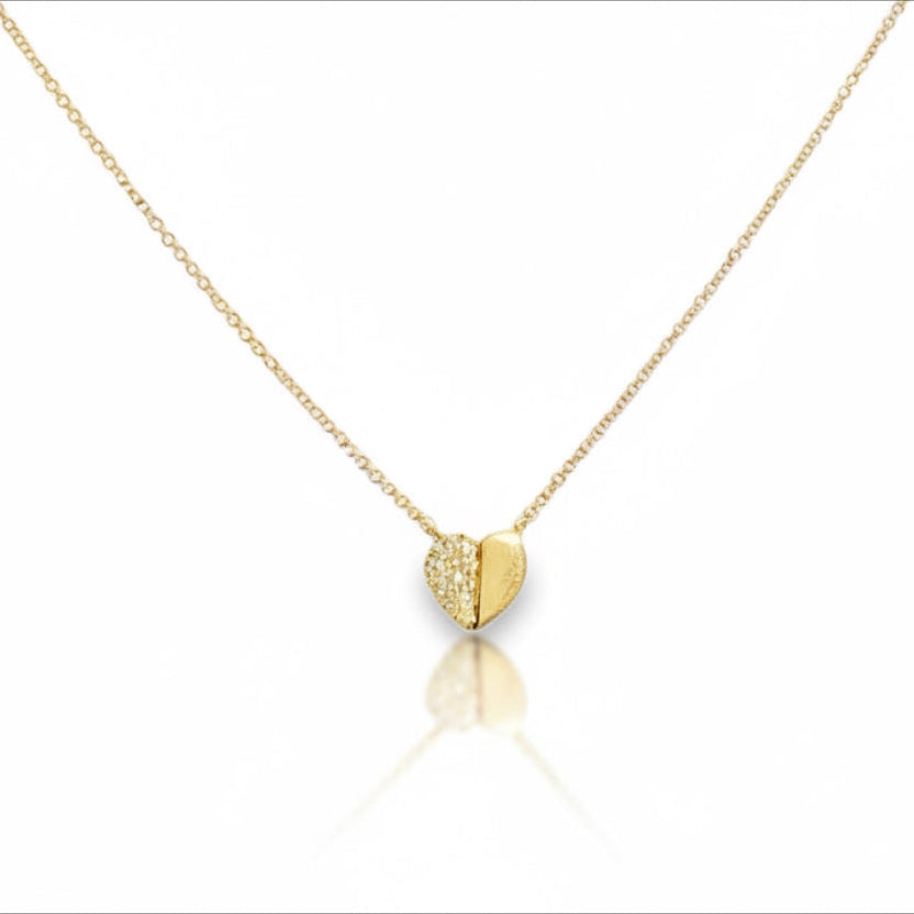 Gold heart-shaped necklace on a white background