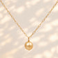 A gold chain necklace featuring a single round, lustrous gold pearl pendant, displayed against a clean white background.