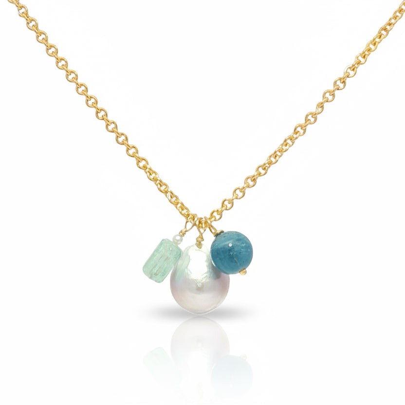Gold necklace with pearls and aquamarine beads on a white background
