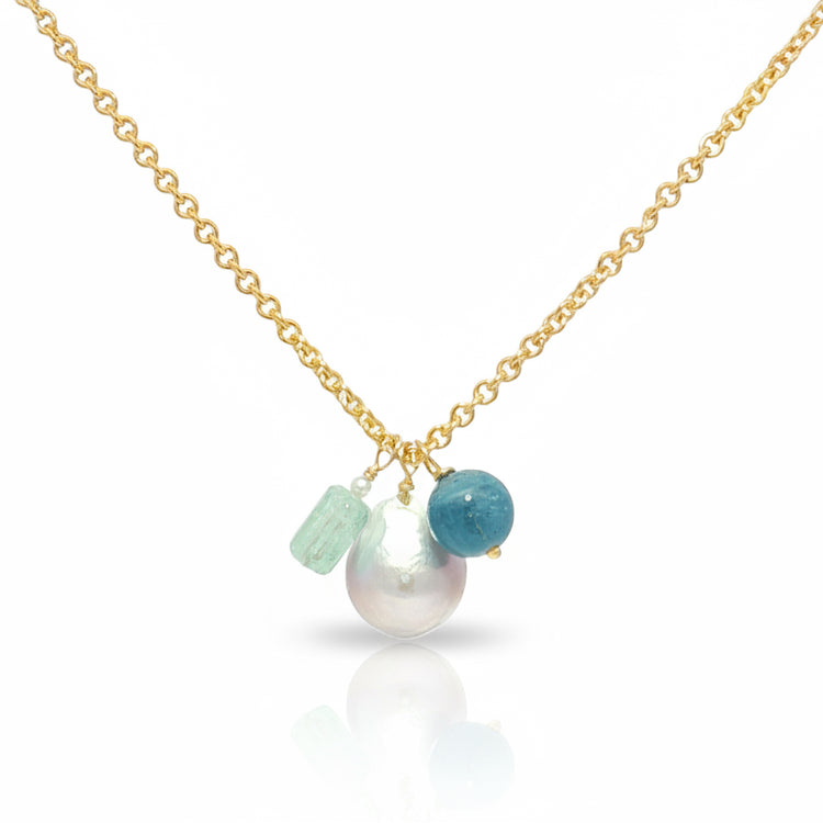 Gold necklace with pearls and aquamarine beads on a white background