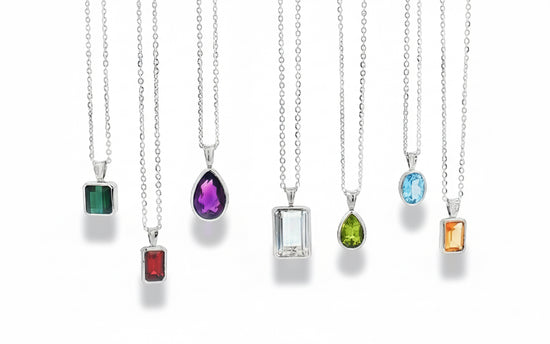 Set of silver necklaces with various colored gemstone pendants on a white background