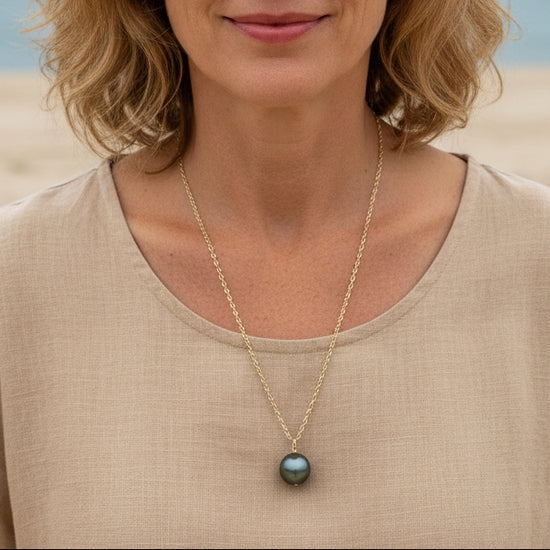 Necklace with a black pearl pendant on a mannequin bust.