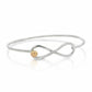 Silver infinity bracelet with a gold accent on a white background