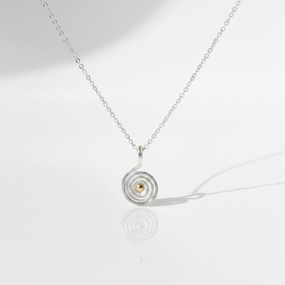 Swirling Waters Necklace on flat white surface with cast shadow