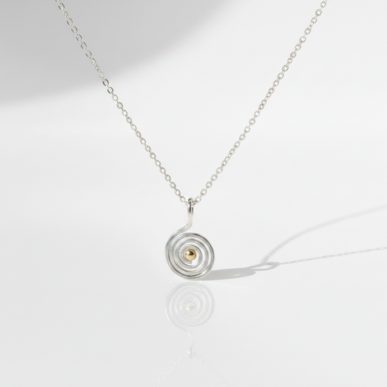 Swirling Waters Necklace on flat white surface with cast shadow