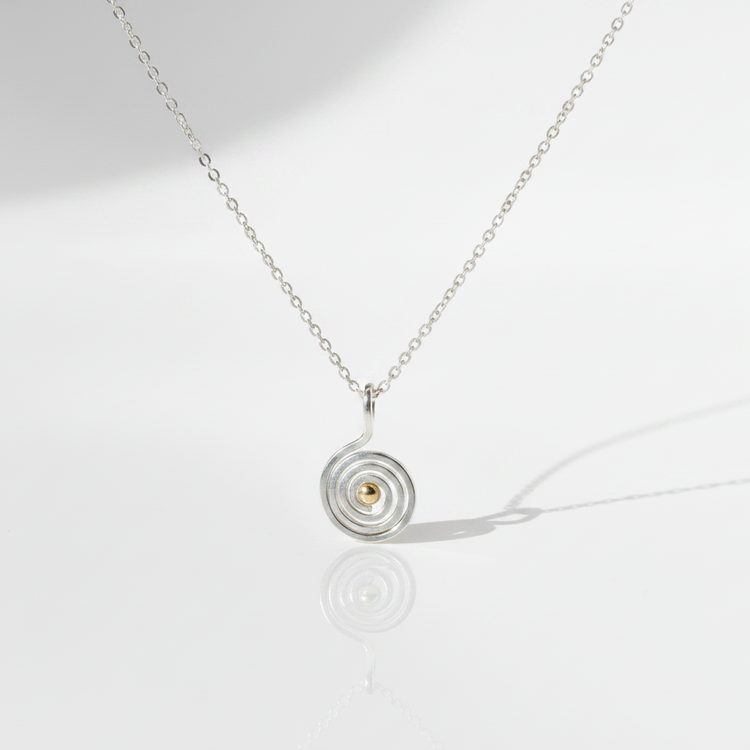 Swirling Waters Necklace on flat white surface with cast shadow